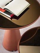 Dettagli del top in vetro cristallo specchiato bronzo, accompagnato alla struttura in poliuretano color paprika