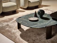 Il piano del tavolo Reef ampio e sagomato, questo modello largo cm 120 ed in pietra marmo selva green, è caratterizzato dalla preziosa bisellatura del bordo