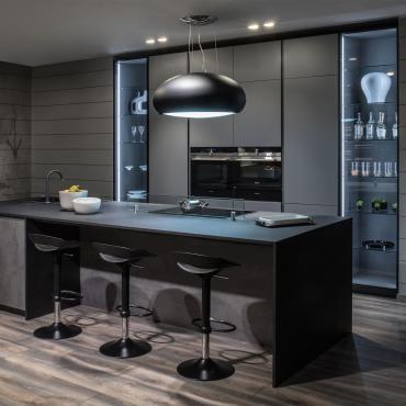Cucina moderna con isola grande centrale su misura e colonne con elettrodomestici e vetrine
