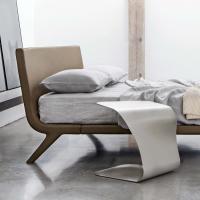 Table de chevet ouverte modelée Duffy en polyuréthane blanc représentée avec le lit Stealth