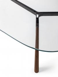 Particularité du plateau en verre cristal transparent mettant en valeur la structure en bois et métal de la table Adelchi