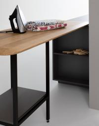 Péninsule utilisée comme table à repasser avec plateau en chêne et cadre en aluminium noir mat