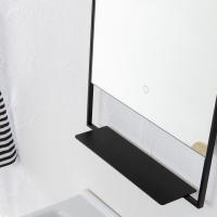 Particolare della mensola portaoggetti fissata sul telaio nero opaco dello specchio da bagno Polluce