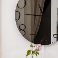 Détail de l'horloge miroir murale avec ses aiguilles en aluminium noir, Moment de Cattelan