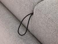 Gros plan sur le cordon permettant de faire pivoter le dossier : lorsque le canapé-lit est fermé, le cordon est caché dans l'espace entre les deux coussins