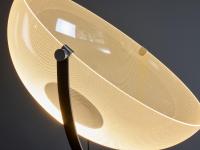 La sottile struttura in metallo, che congiunge il cono di luce al basamento, è disponibile sia verniciata bianca che nera e permette di orientare la lampada a seconda delle proprie necessità