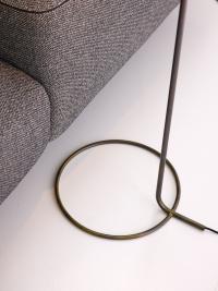 Détail du socle : une fine tige circulaire en laiton bruni, assortie au support vertical contenant le câblage.
