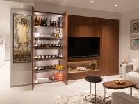 Armoire de salon avec espace TV, niche pour déposer des objets, armoire haute et compartiment de rangement avec étagères et coin bar.