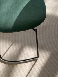 Chaise verte design Keel - Détail de la base de l'assise en polypropylène assortie à la structure métallique anthracite avec le coussin supérieur rembourré et recouvert de tissu