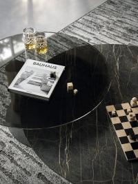Contraste des matériaux entre la table pivotante en verre fumé et le plateau en pierre céramique de la table basse Arena Keramik