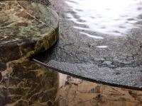 Détail de la combinaison du plateau en verre martelé et du cylindre en marbre Verde Alpi, deux caractéristiques qui rendent la table basse Piece immédiatement reconnaissable.
