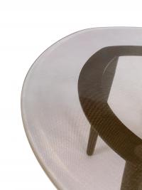 Détail du plateau en verre à la bordure adoucie et structure visible en métal laqué noir