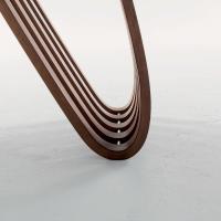 Détail de la Précieuse courbure de la base en bois de la table extensible design Arpa