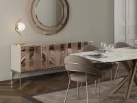 Credenza moderna con basamento in metallo Moma perfettamente inserita all'interno di un soggiorno con specchio Jolan, tavolo Ivy e sedie Kiki