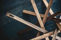 Particolare della base con gambe in legno incrociate - finitura Noce Canaletto