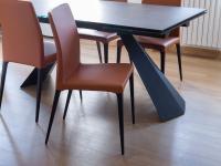 Dettaglio basamento tavolo in metallo verniciato Nero Industry e sedia in pelle con gambe in legno massello