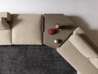 Particolare del tavolino in legno ad angolo inserito tra le sedute imbottite del divano Holiday (acquistabile in scheda a parte)