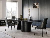Tavolo Torquay con basamento in metallo verniciato nero e piano in marmo Sahara Noir, nella versione sagomata