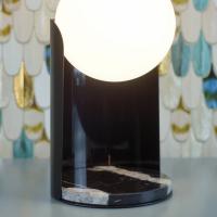 Dettaglio della lampada Dew da tavolo: si nota la base in marmo nero Marquina