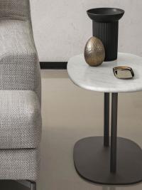 Tavolino basso ovale Caleb con base e montanti in metallo verniciato Moka Shine, qui impiegato lato divano