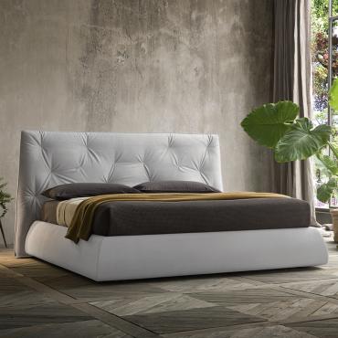 Iguana bed with an asymmetric tufted headboard