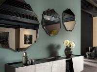 Medea shaped mirror with metal frame by Cantori used in an arrangement to enhance a wall