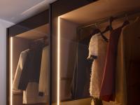 Particolare delle ante scorrevoli in vetro trasparente grigio - risalta l'illuminazione interna con barre LED verticali incassate nei fianchi