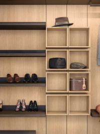 Open compartments in natural oak fashion wood, next to shoe-rack shelves with heel pads