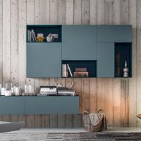 A wall-mounted composition featuring Plan wall units with hinged and drop-down doors in matt lacquer (Pacific), with a lightweight effect thanks to the Plan Scacco open wall units in matt lacquer (Night Blue)