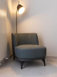 Low armless two-tone armchair with Cloud faux leather covering and Valentino petrol coloured fabric cushions.