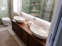 Bathroom cabinet with double countertop washbasin and slatted wooden frame.