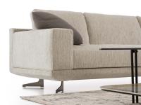 Modern sofa with square armrests and tall legs made from black nickel