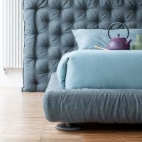 Bed frame with soft fabric or faux leather upholstery and matt lacquered round feet