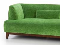 Detail of the soft shapes of the Greg sofa supported by a wooden base