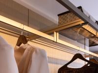 Metal and glass shelves with integrated LED lighting, available as part of the Horizon Lounge walk-in wardrobe equipment