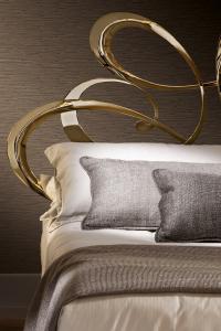 Detail of the swirling precious headboard, whose delicate volume has been obtained by cold bending and laser cut