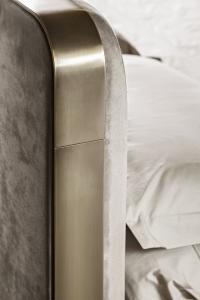 Rounded headboard corners bordered with a flat metal frame which adds an industrial touch