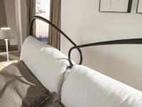 St. Tropez by Cantory has a curved full iron headboard with upholstered cushions tied with a classy bow