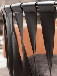 Detail of the curved iron backrest with twisted leather bands