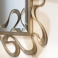 Nastro mirror for classic bedrooms has a ribbon metal frame with a champagne slver leaf finish