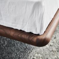 Close-up of the rounded bed frame in Canaletto walnut