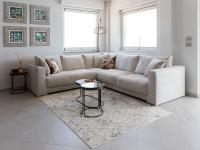 Clive corner sofa in white Diamond fabric, with side tables on the front and side of the sofa.