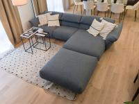 Sofa with chaise longue in blue fabric, with decorative cushions, side tables, rug