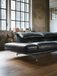 Close-up view of the Heritage sofa upholstered in black leather with horizontal padded armrests