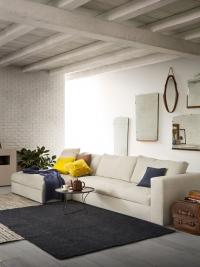 The Holiday sofa with low feet and backrest cushions, upholstered in white fabric