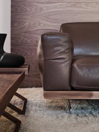 Detail of the walnut base of the Raymond sofa with its wide armrests