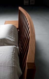 Detail of the curved headboard in natural walnut wood