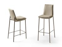View of the Dalila stool from the front and back. Kitchen countertop and snack-bar countertop versions. Leather upholstery and metal legs in a Bronze finish.