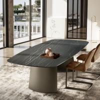 View of the Edwin fixed table with sail-shaped base from the side. Shaped tabletop in Matt Portoro ceramic and base in Titanium-finish painted metal.