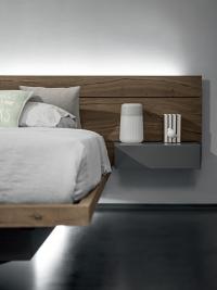 Close up of the slim wooden bed frame with built-in storage box, which is recessed under the bed to give a floating effect
